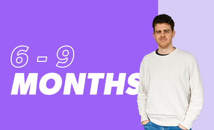 6-9 months with a graduate looking at camera with arms in pockets